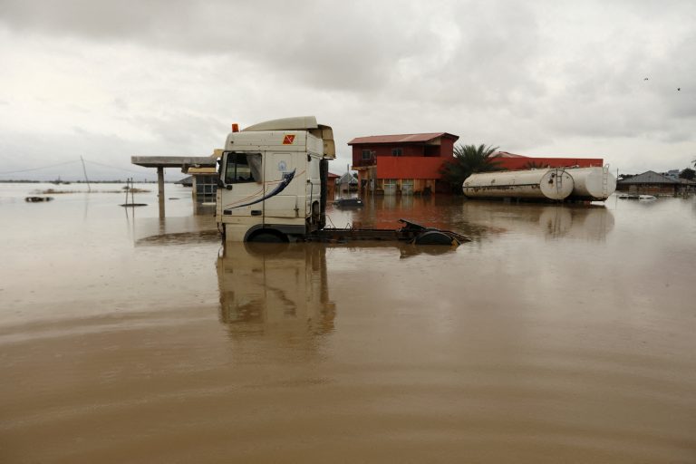 Vehicles are seen submerged in flood water at a petrol station in Lokoja